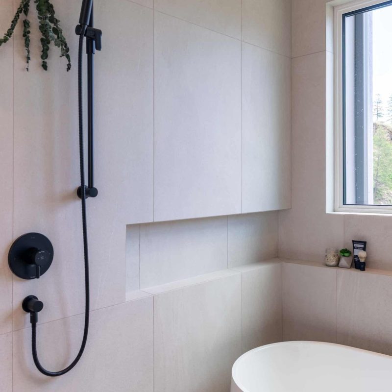 Sleek black fixtures and minimalist design, proving shower details can be stunning.